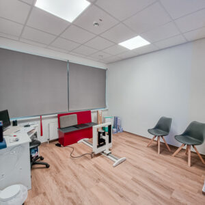 Ein Beratungszimmer mit Tisch und Stühlen, medizinischer Ausrüstung an der Seite.