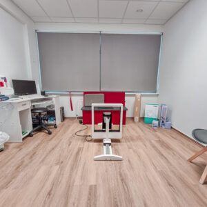 Ein Beratungszimmer mit Tisch und Stühlen, medizinischer Ausrüstung an der Seite.