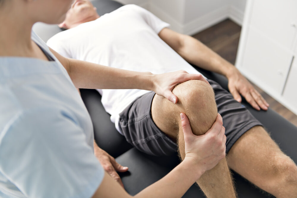 Patient at the physiotherapy doing physical exercises with his therapist Patient bei der Physiotherapie