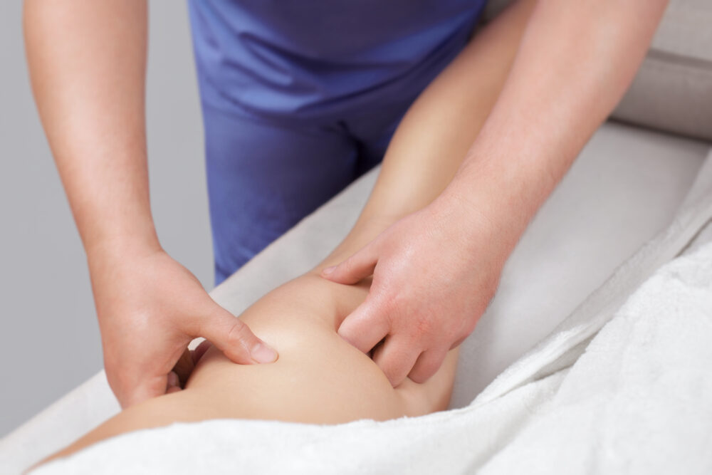 The masseur makes Anti-cellulite massage on the buttock and thighs of the patient.
