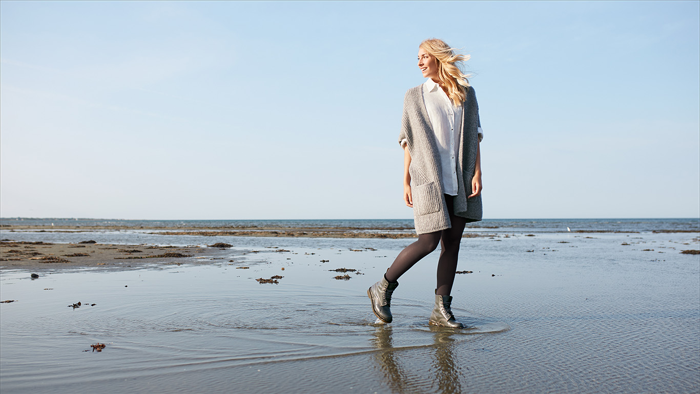 Junge Frau mit Kompressionsstrümpfen am Strand